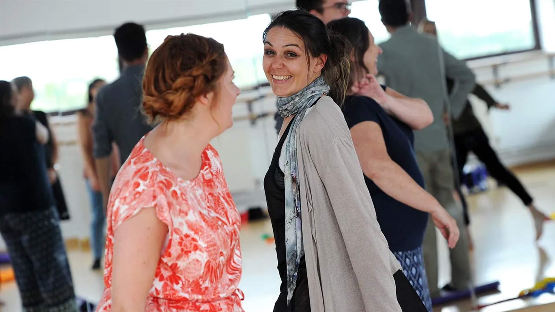 Two women smiling and dancing.