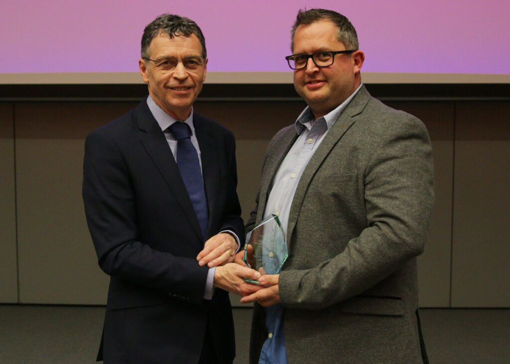 Professor Andy Smith, Sport and Physical Activity, stood with Mark Allanson, Pro Vice-Chancellor (External Relations), collecting his glass award.