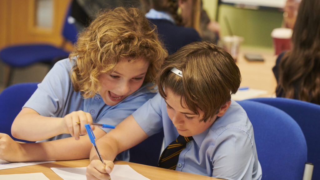 Two primary school aged children in a classroom.