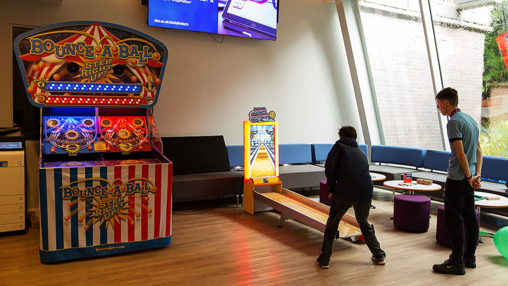 New students play an arcade game at the Gaming Café during Induction Week