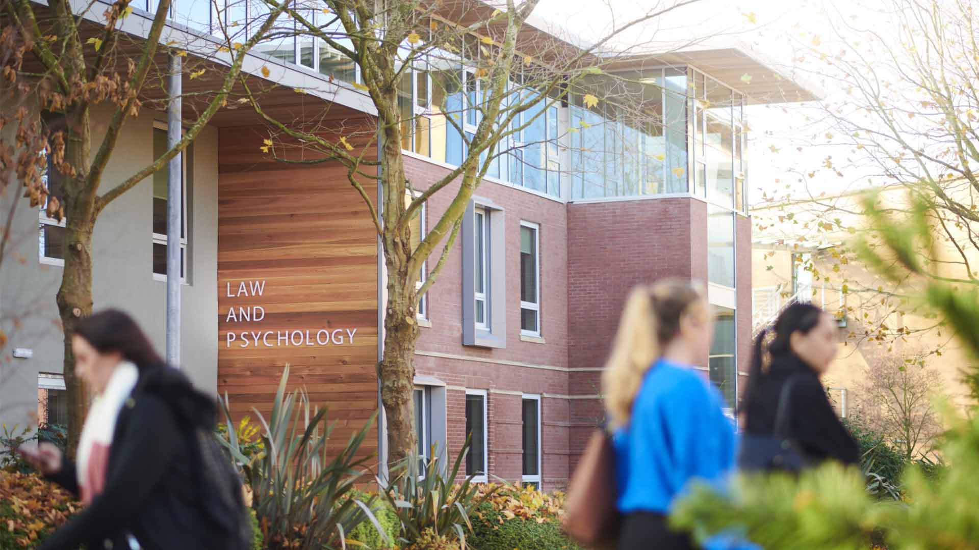 Edge Hill students on campus walking past the Law and Psychology building.
