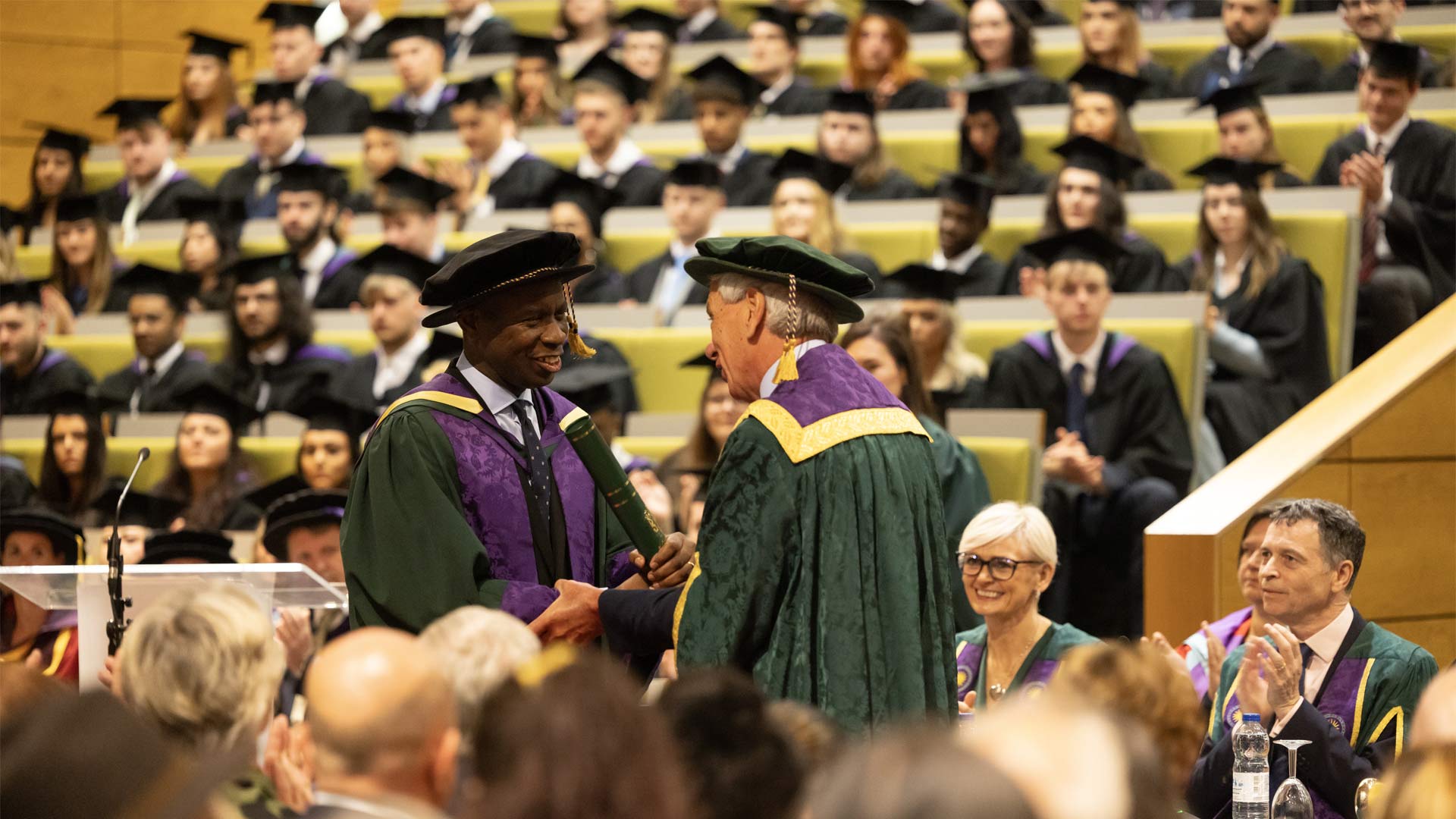 Clive Myrie accepting his honorary graduate award from John Cater