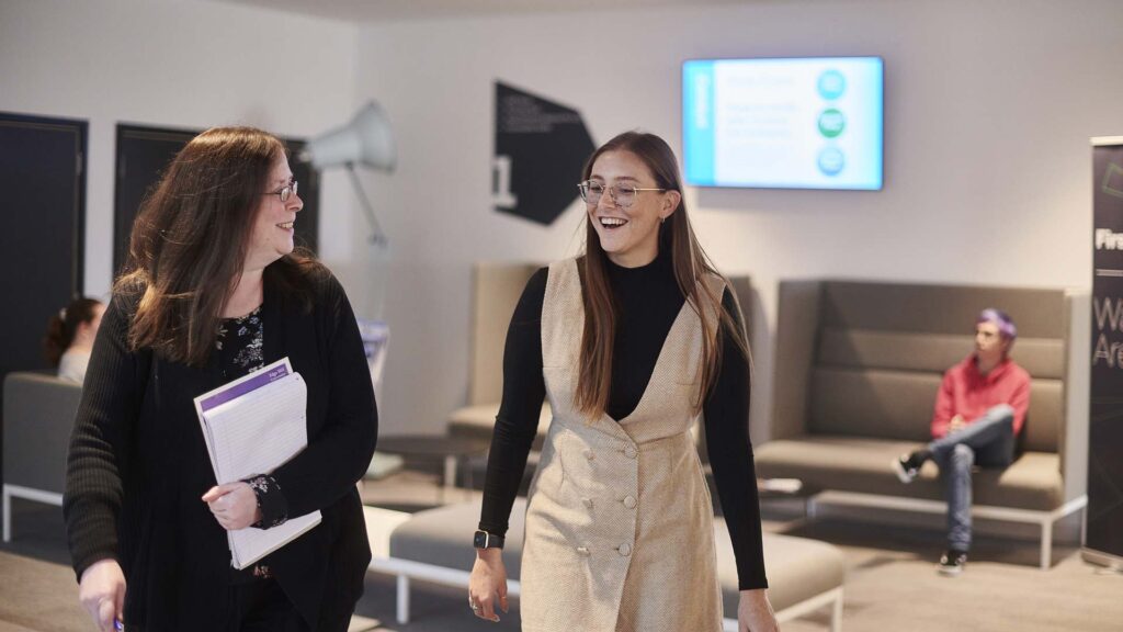 Female student smiling with support adviser in the Catalyst building