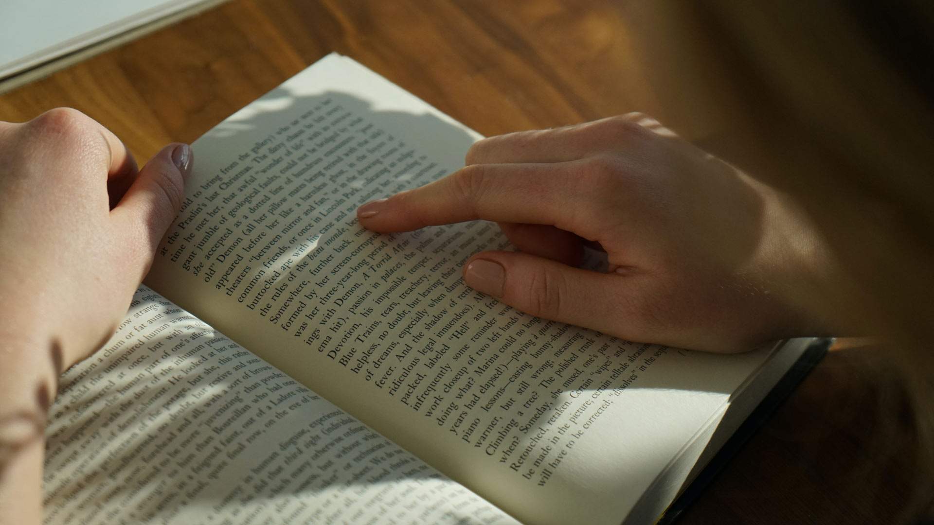 A photograph form behind of a person reading an unspecified book