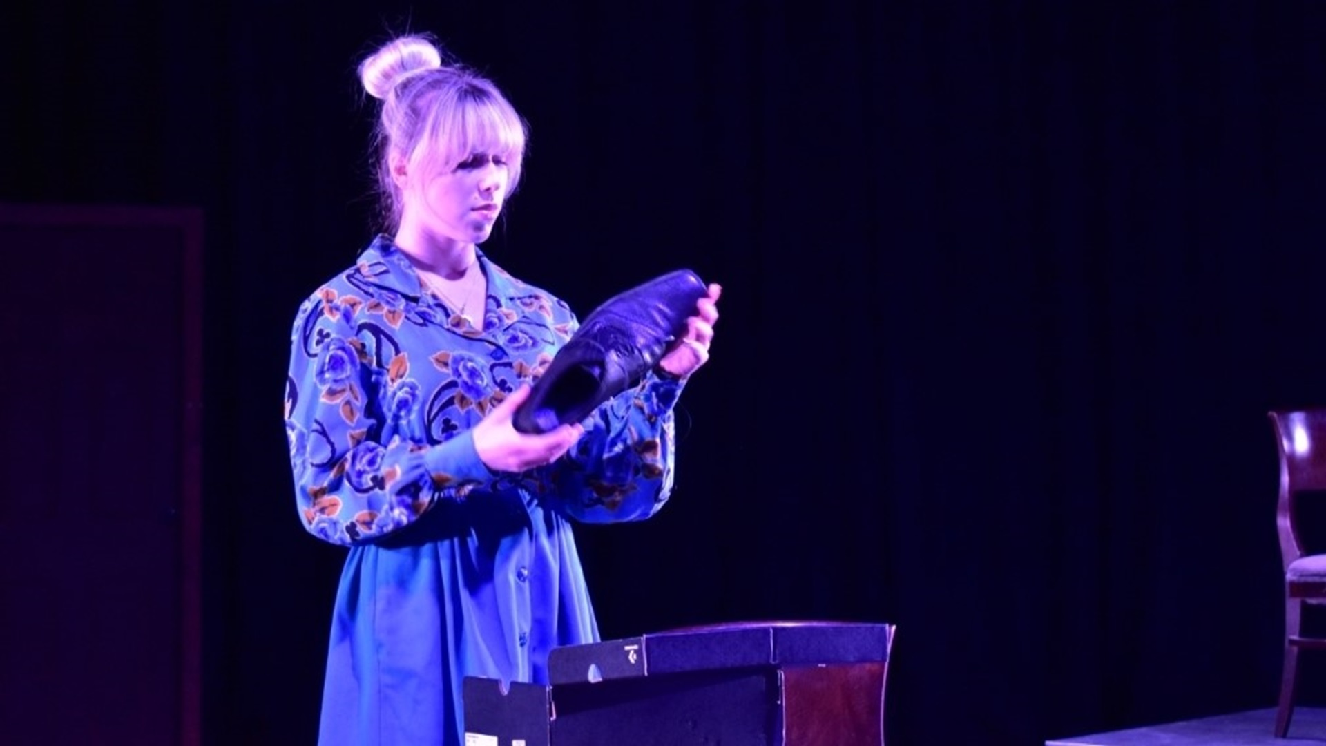 A picture of Shannon Fleming on stage performing a play.