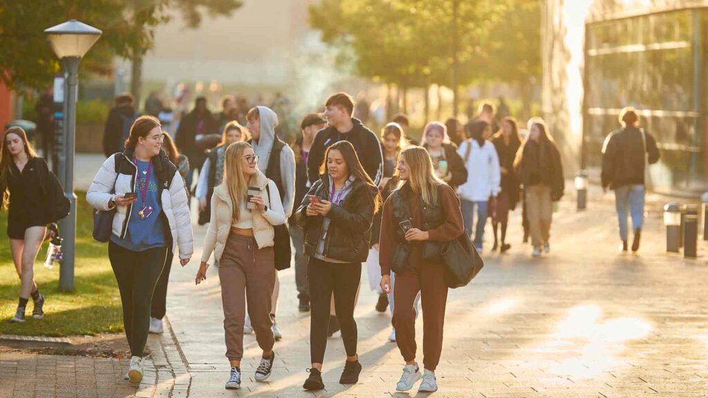 Image of students walking across campus together along the boulevard by The Hub