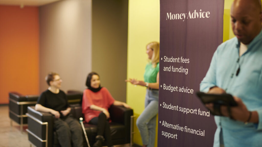 Students gather at a stand about Money Advice on funding and fees.
