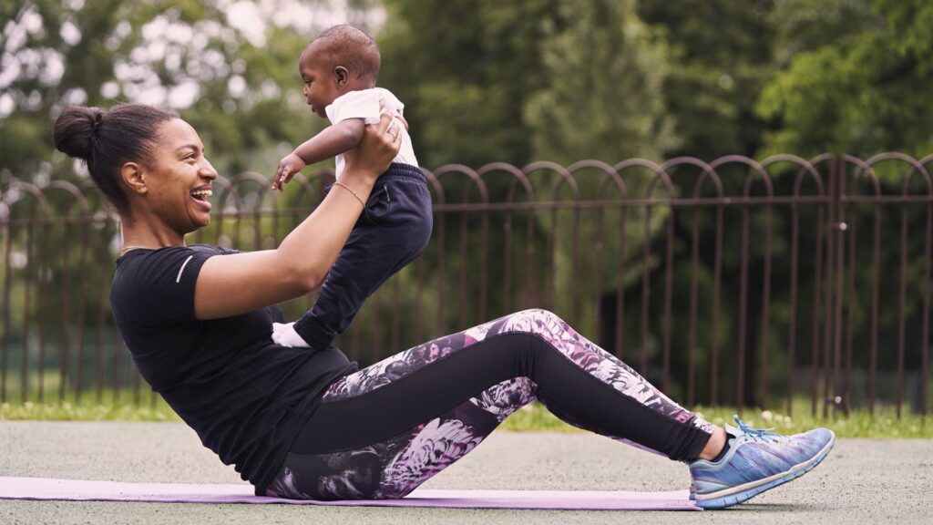 A parent in gym wear holds their baby