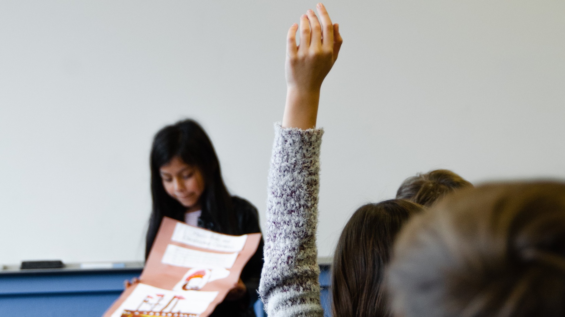 Student raising hand at book launch.