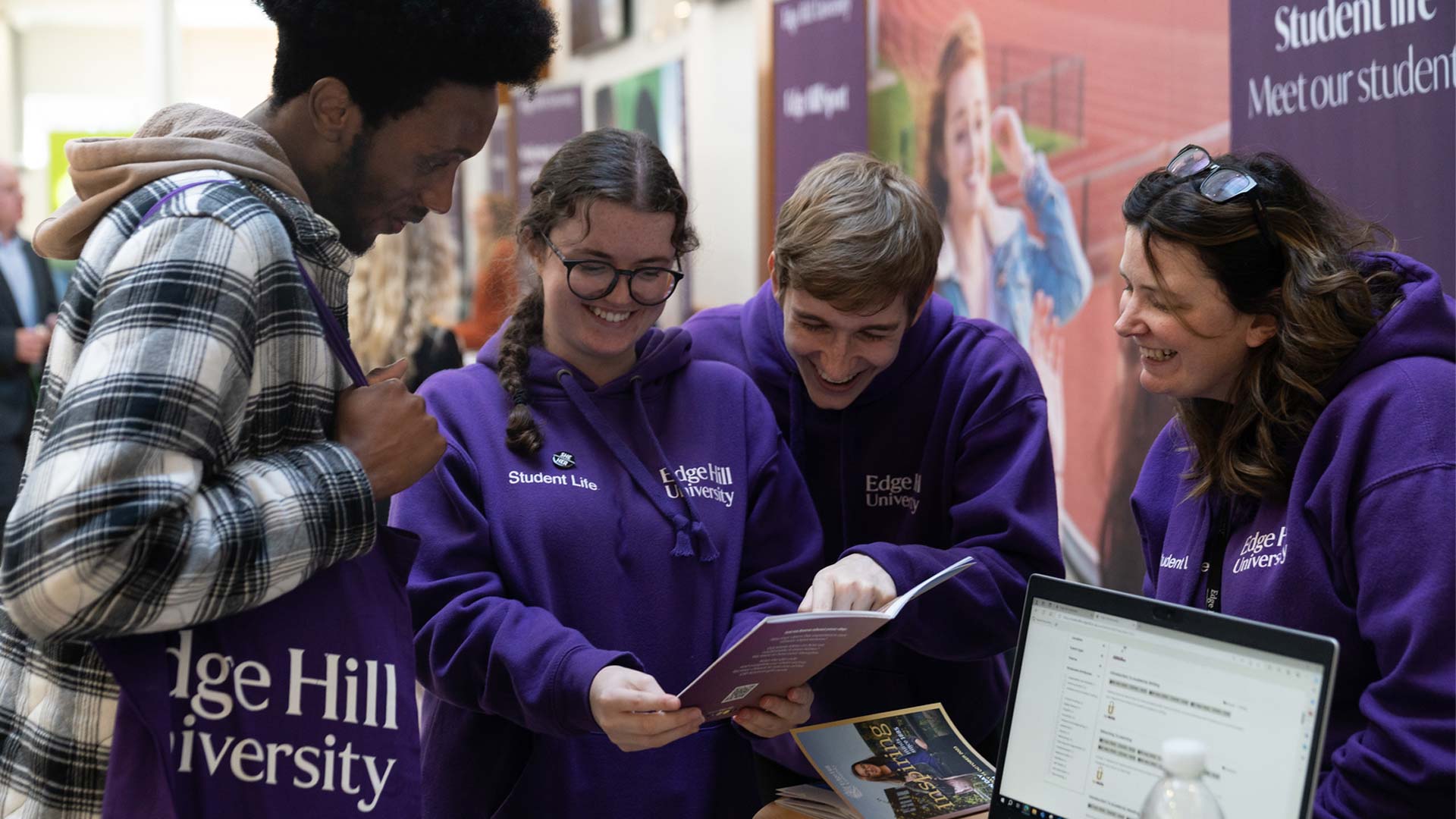 Image of visitor chatting with student guides and staff at the student experience fair during open day