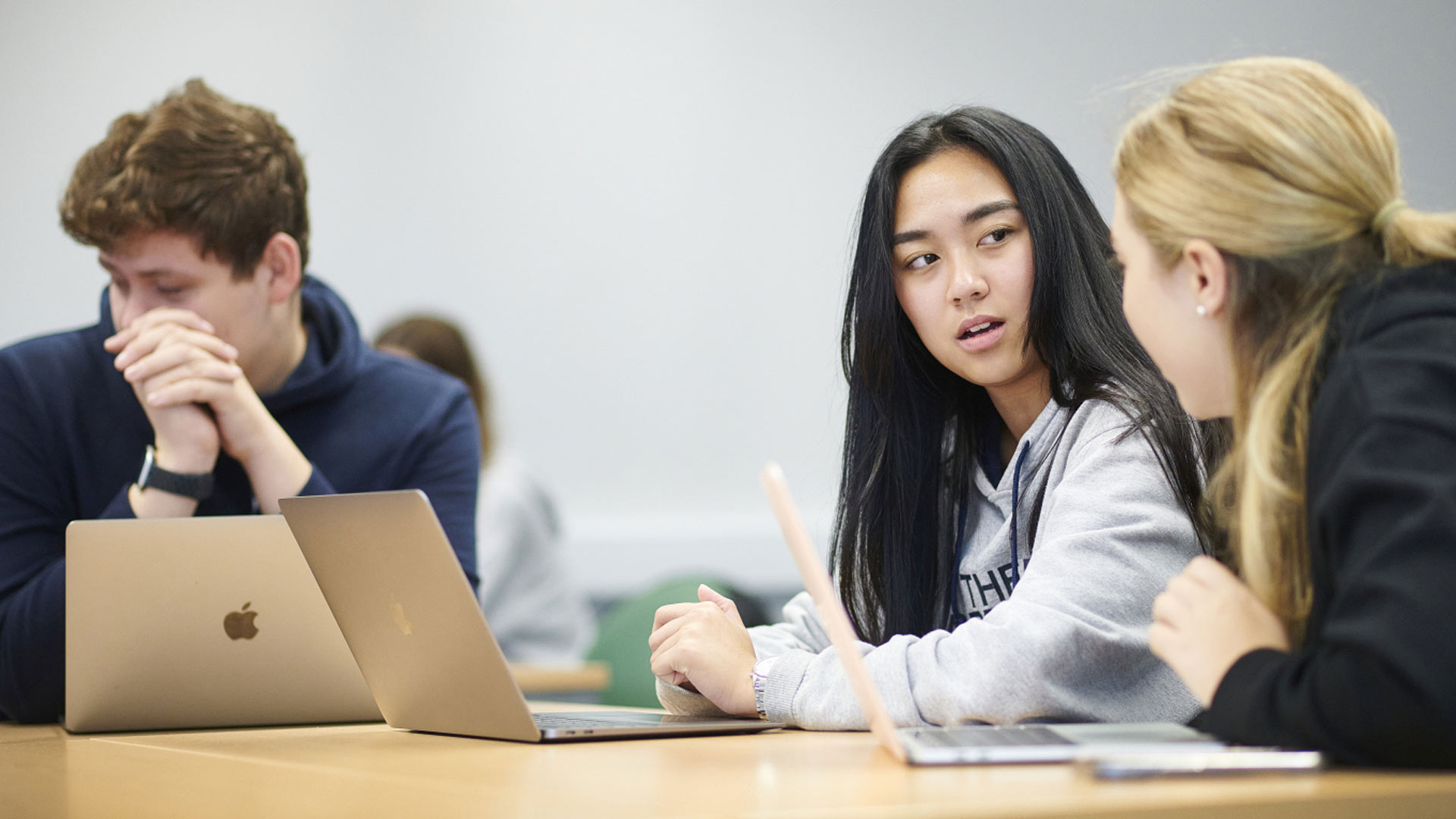 Students at a desk with laptops