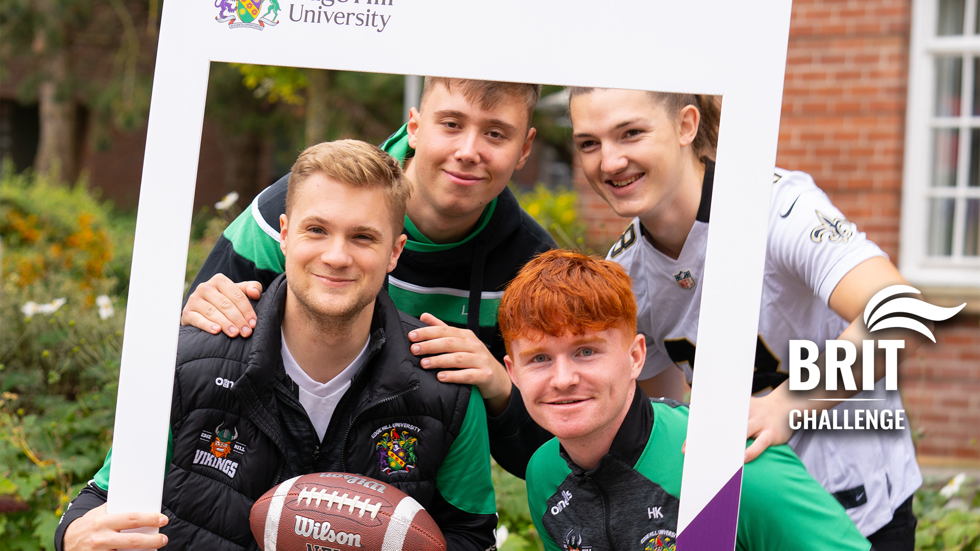 group of sports students getting a picture through an Edge Hill selfie frame. BRIT Challenge logo is in the bottom right hand corner