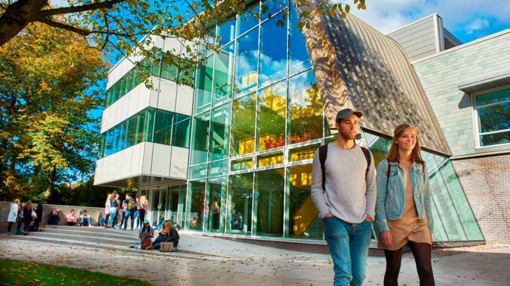 An exterior shot of the Tech Hub, with two students in the forefront of the image.