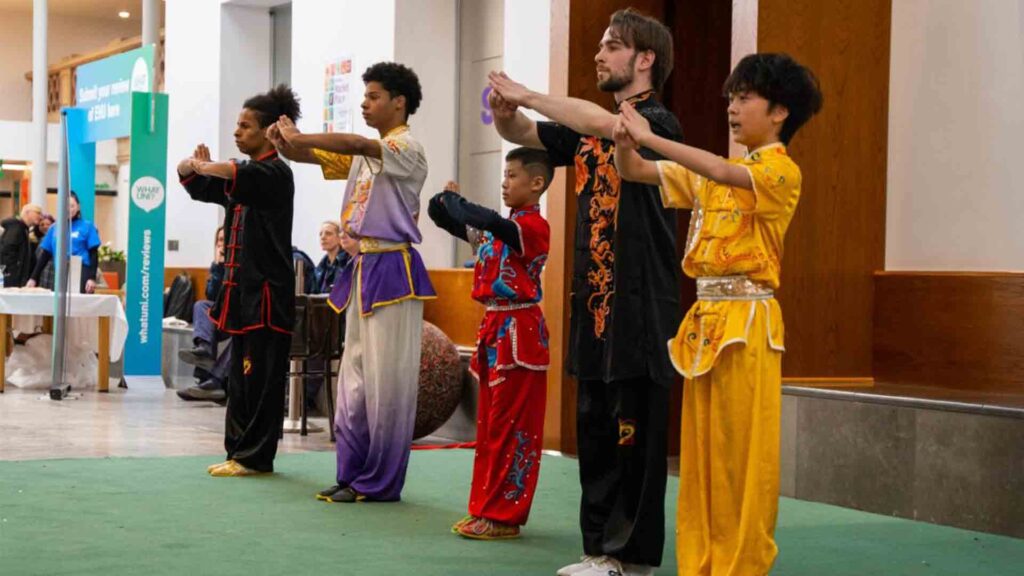 Student stood in a row taking part in group martial arts at the Chinese New Year event.