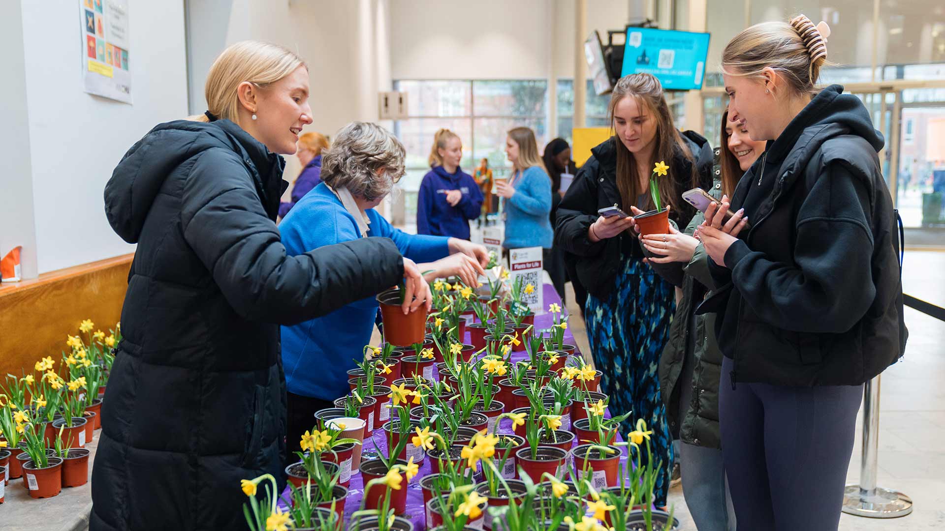 Students and staff giving out plants as part of a university sustainability event.