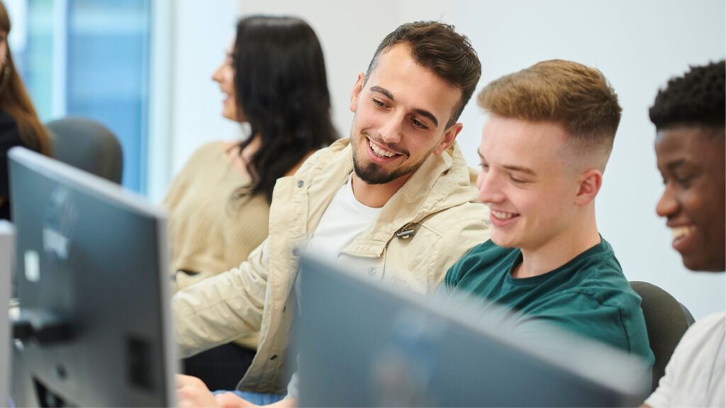 Students sat at a computer.