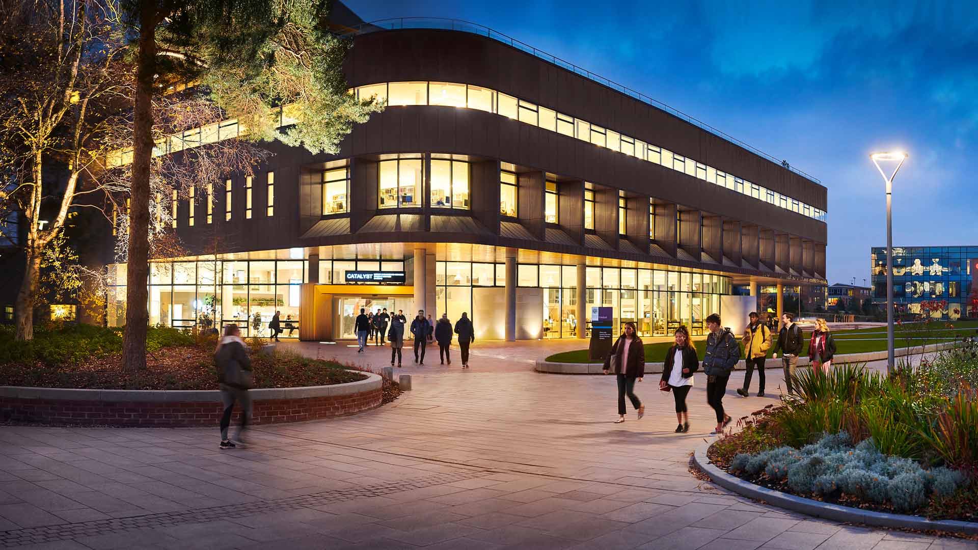 Catalyst building and students at night on campus