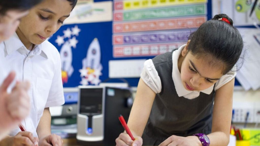 Children completing an exercise together in the classroom.