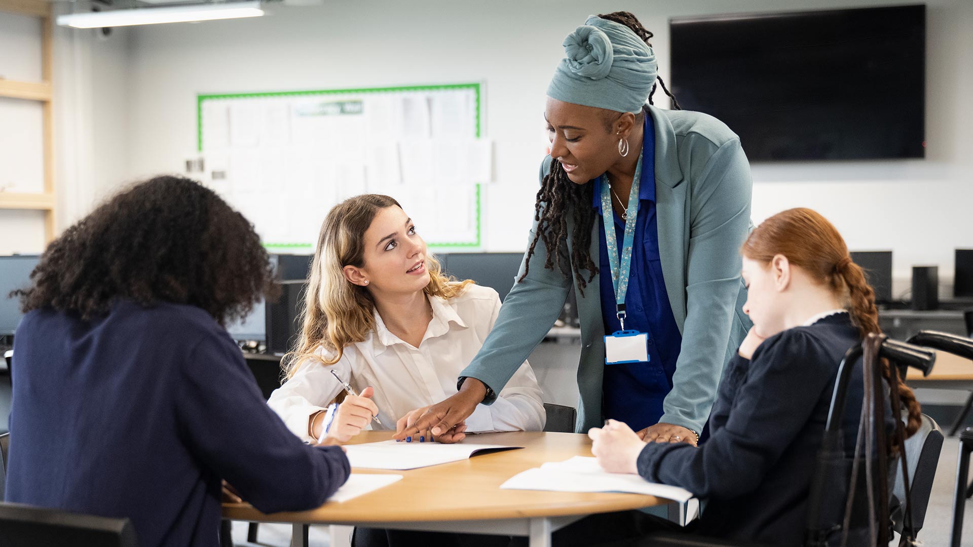 Students working on an assignment with support from a teacher