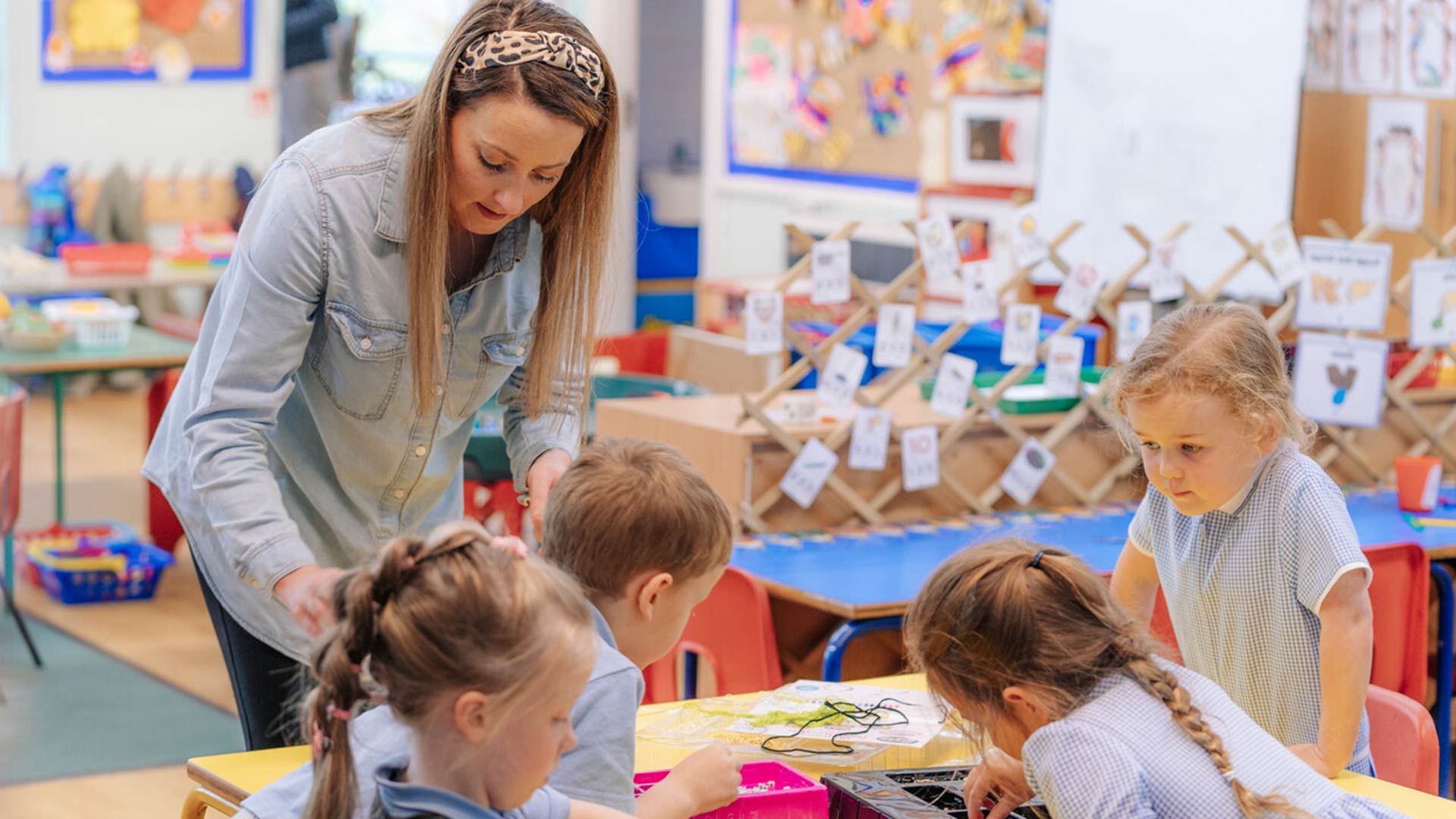 Teacher working in classroom on activity with young children