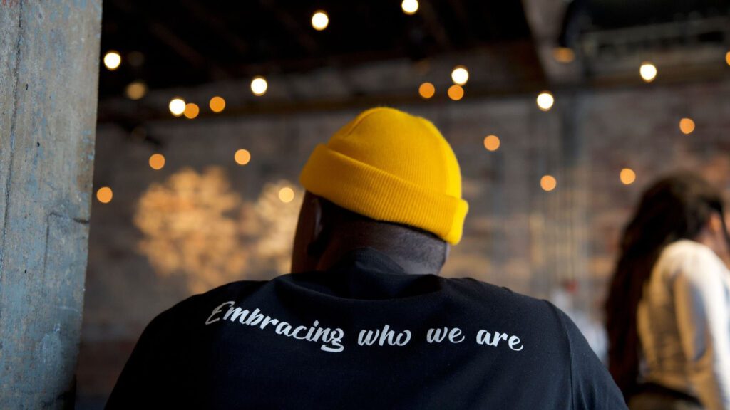 Person wearing t shirt saying embracing who we are.