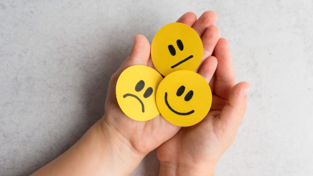 Open hands holding circular discs with smiley faces