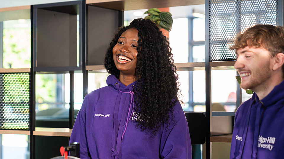 female campus connector in purple jumper at the student life arch
