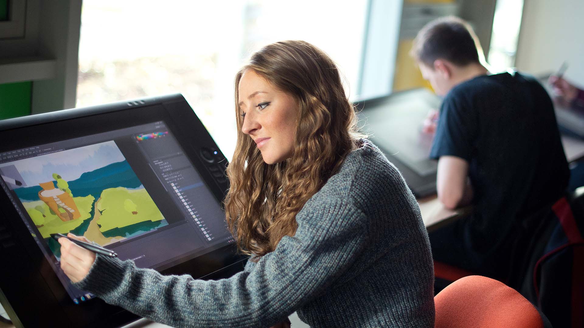 A student working on animation using a touch screen and stylus.