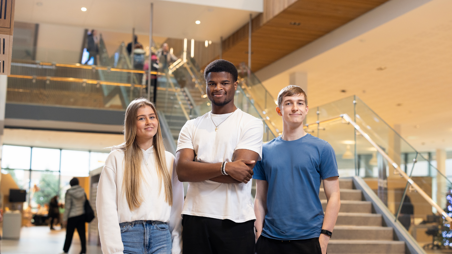 three students stood in catalyst near staircase