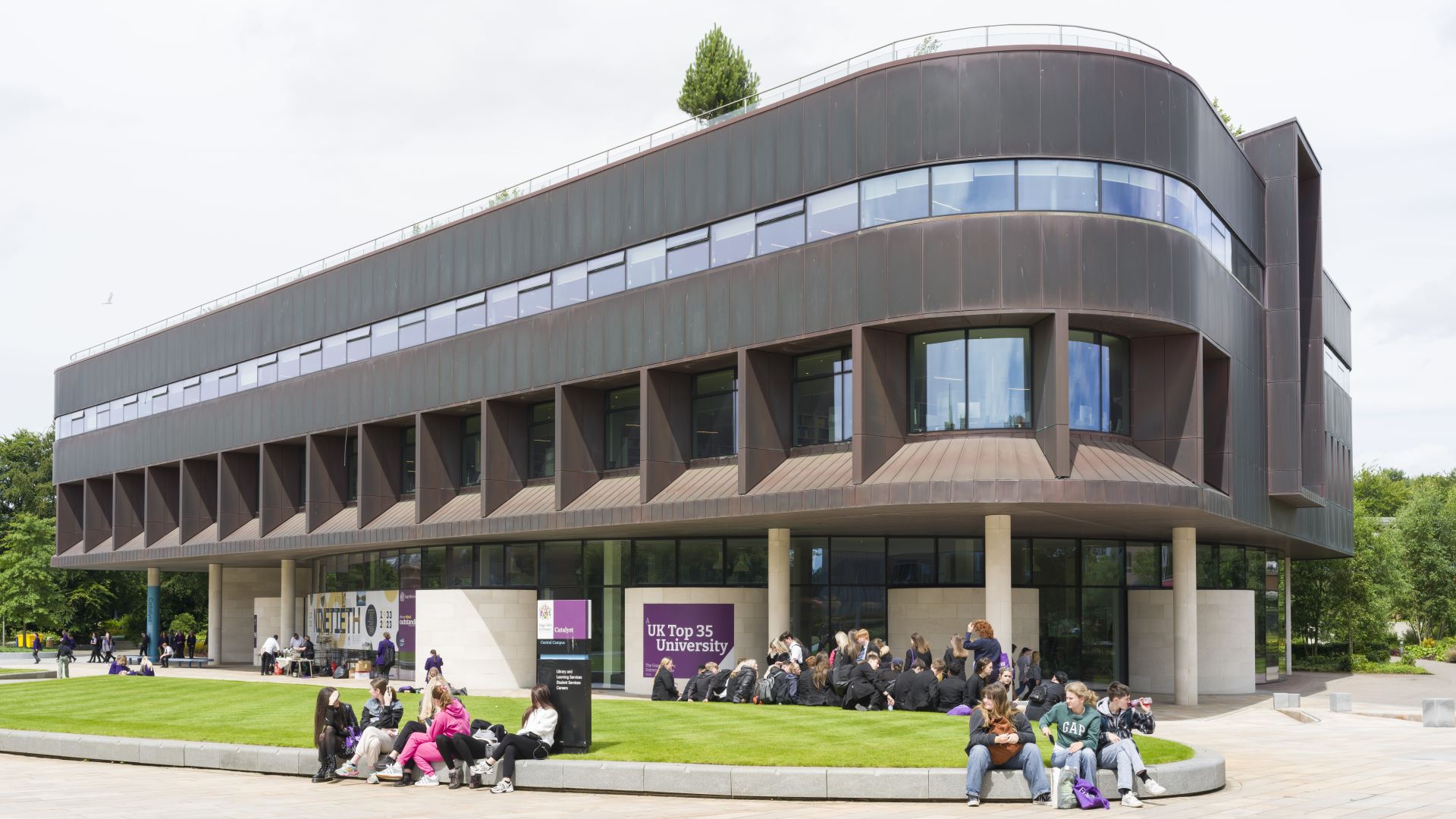 University campus with students sitting outside.