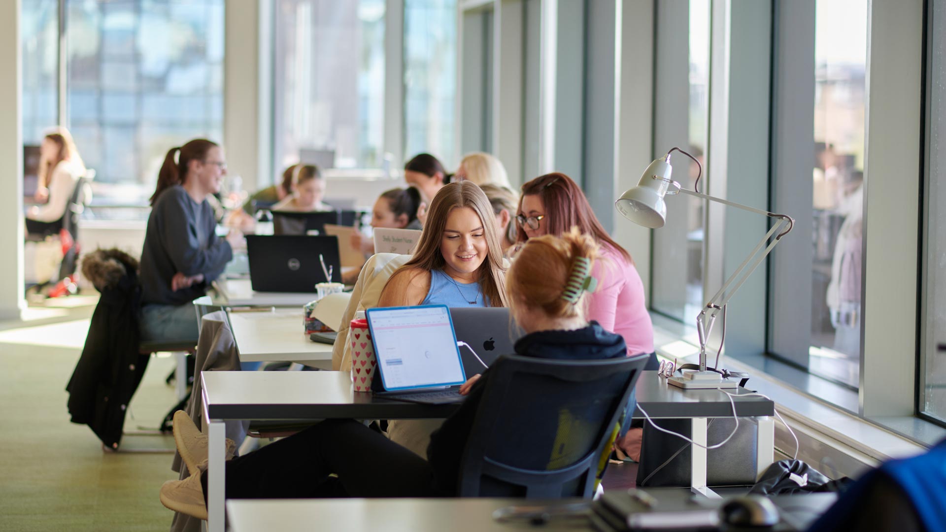 Students working at a computer in a communal space