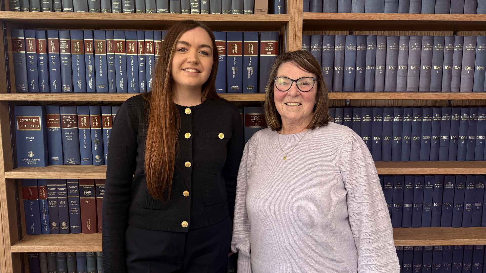 Wigan FC MD Sarah Guilfoyle and Non-Executive Chair Brenda Spencer, stand in front of law books at Edge Hill University.