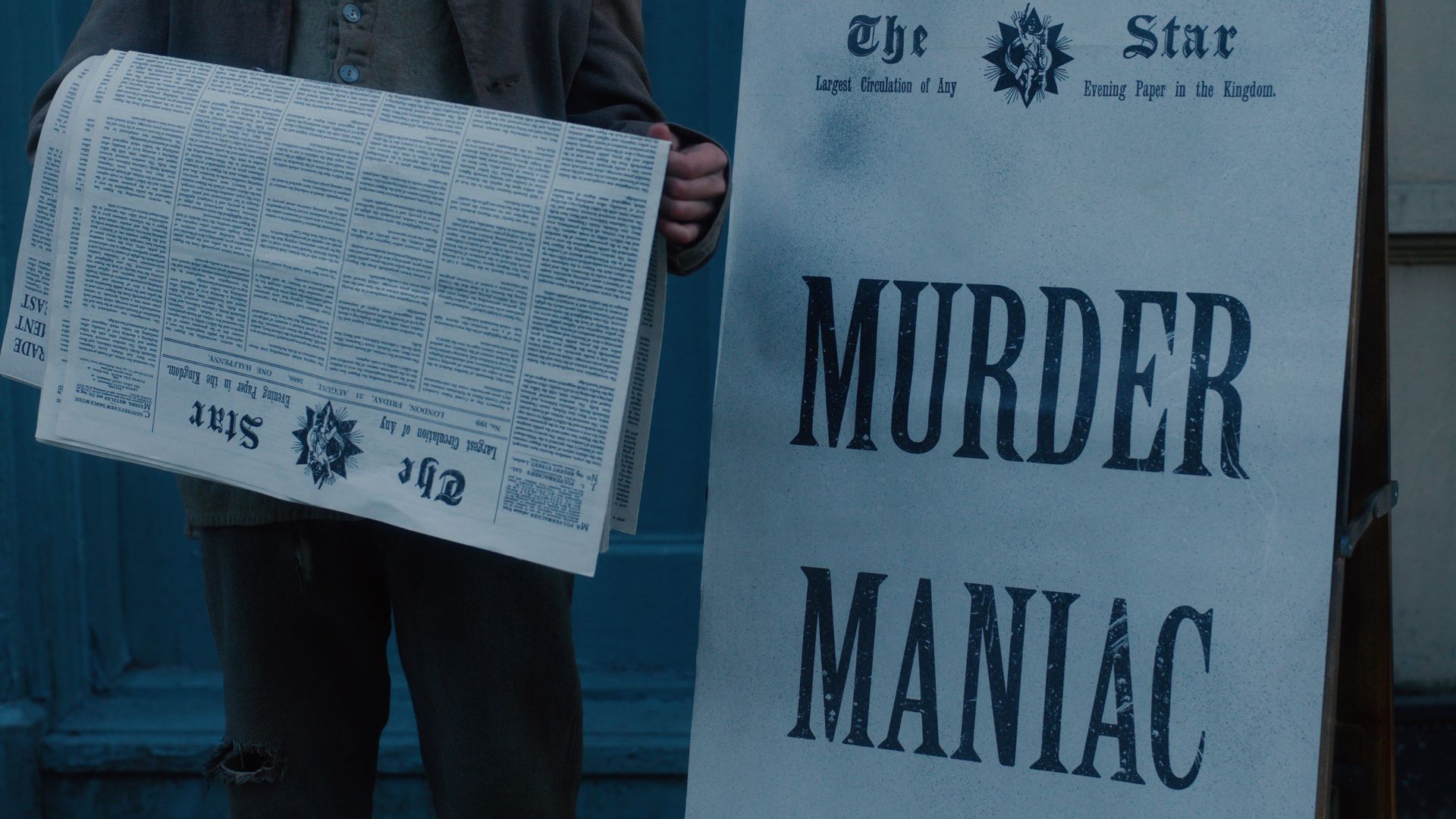 An A-board displays the headline 'Murder Maniac'
