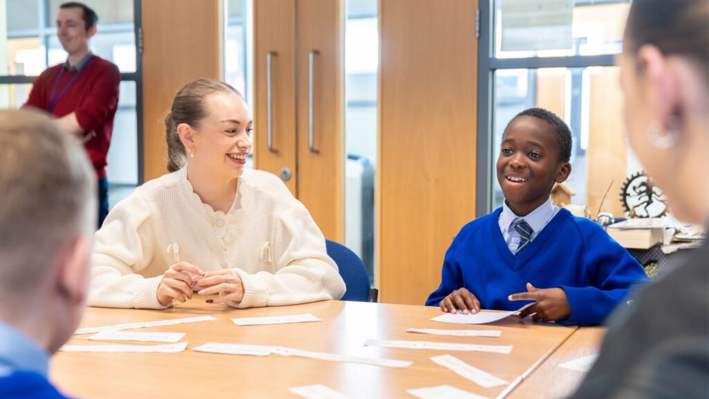 Student sat with child at desk