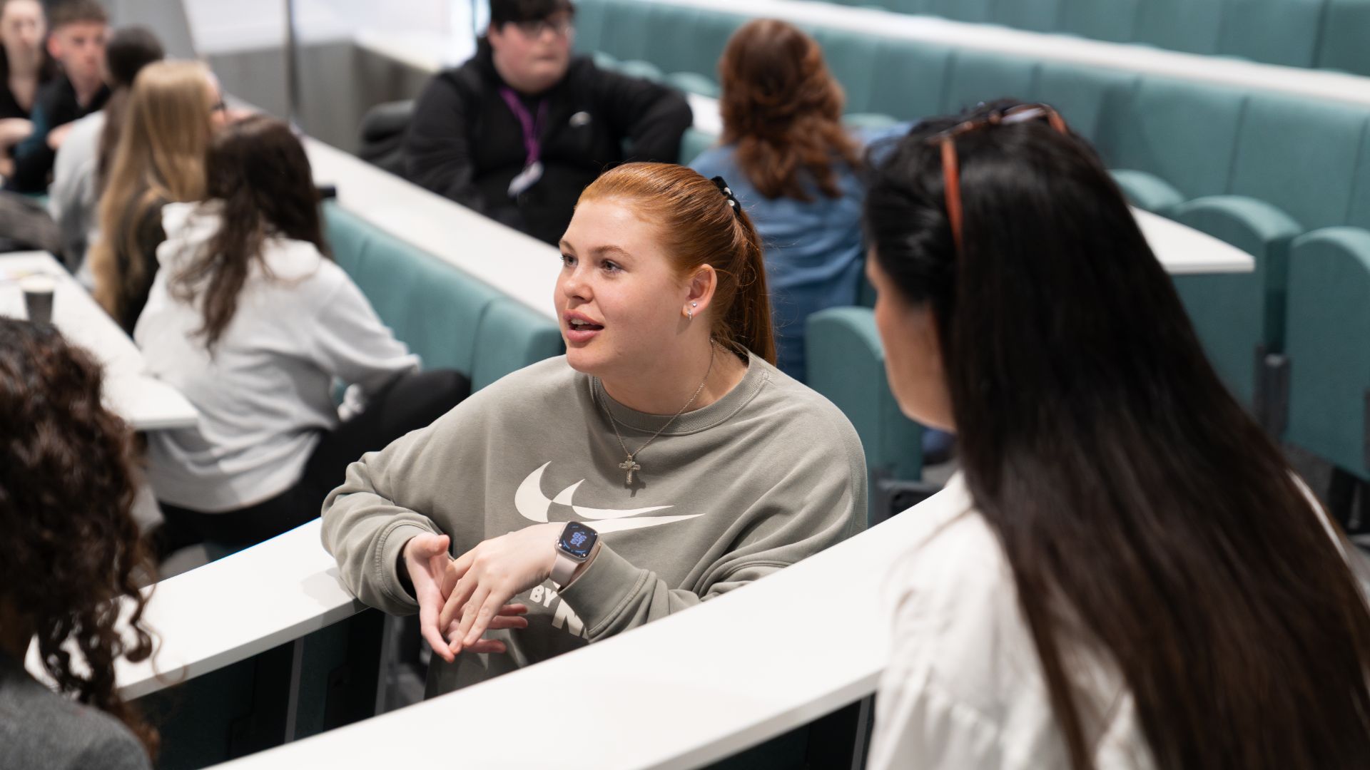 education students in lecture theatre engaging in group discussion