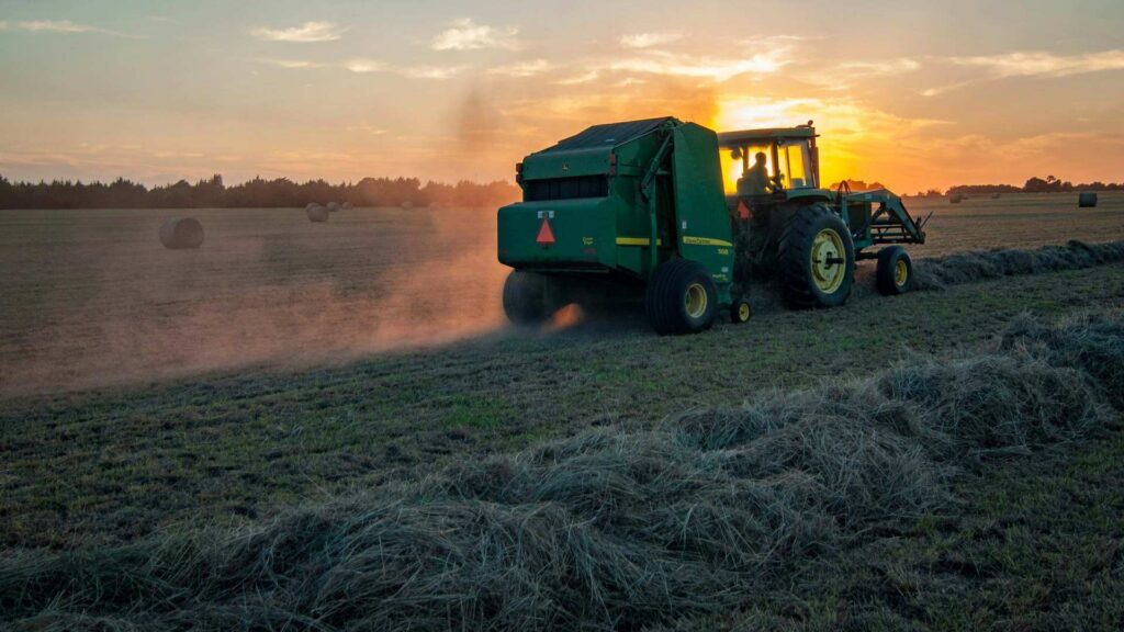 a green field with green tractor on it.