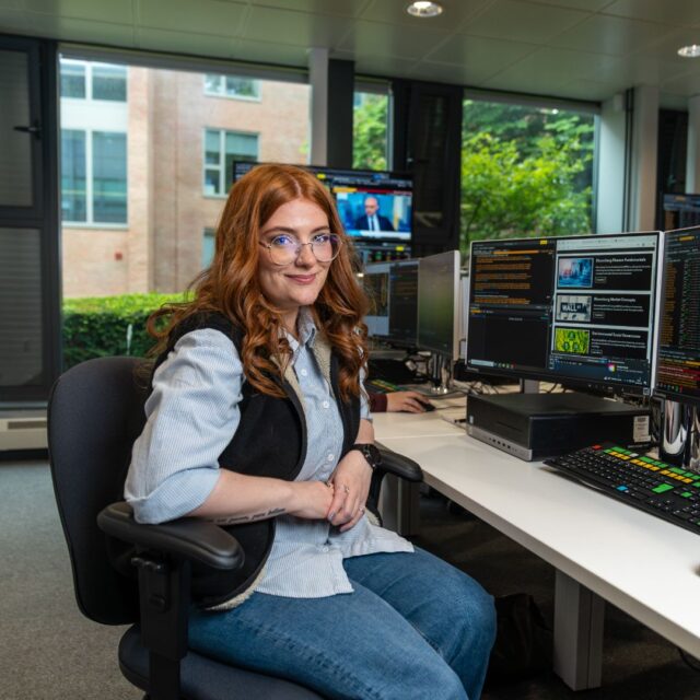 Lauren O'Brien sat in Bloomberg Suite. Computer screens with Bloomberg software are on display