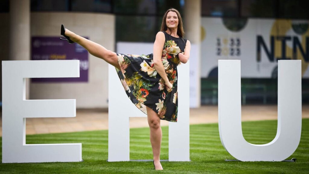 Amy Truesdale MBE Amy Truesdale MBE performing a side kick in front of 4 foot EHU letters