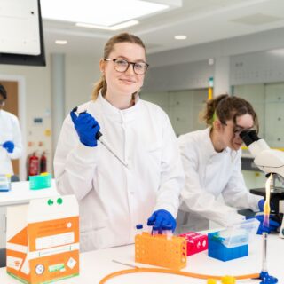 Alice Thomas stood in a lab