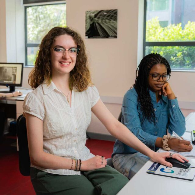 Madeleine Fyers profile photo, sat at a desk with a computer
