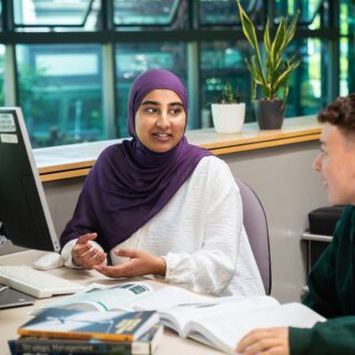 Esha Rahim discussing a business project with fellow student