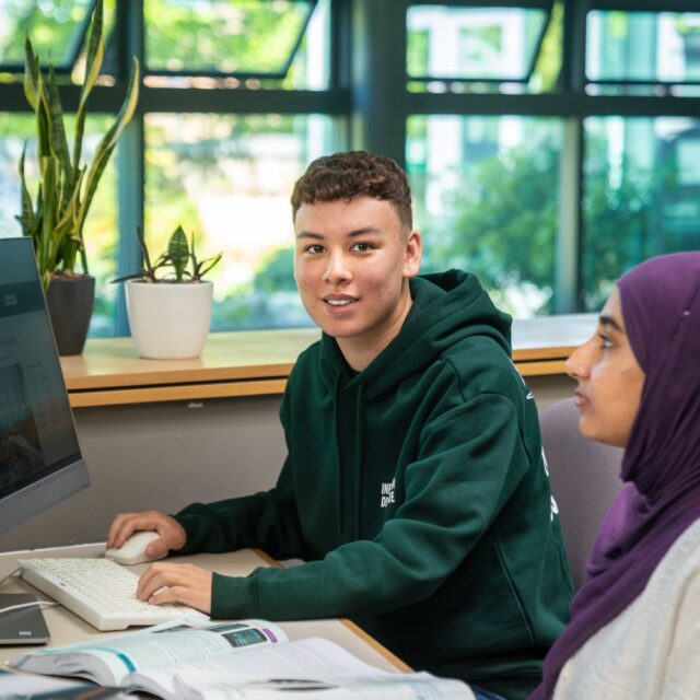 Alex sat at a computer with books out on the desk