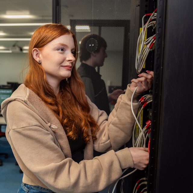 Evie Tarbuck ensuring all the wires are connected correctly to the server