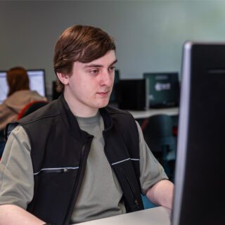 Luke Chadwick working on the computer in one of the computer rooms