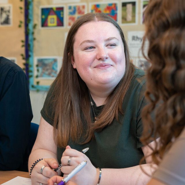Amelia Burr listening to a pupil in class