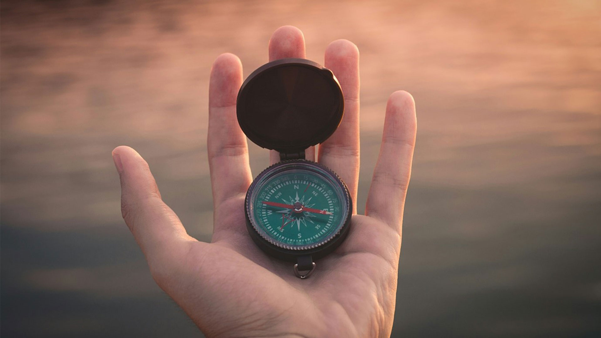 A compass held in a hand