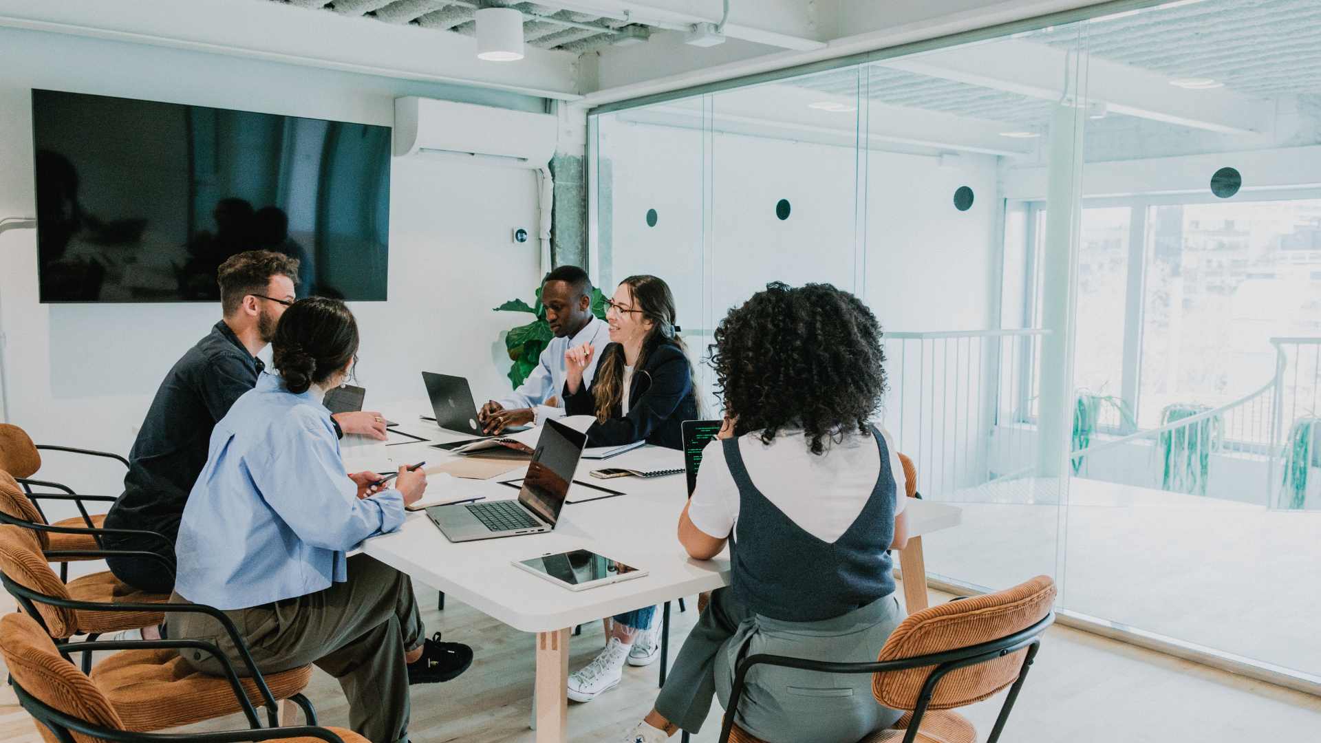 People sat in an office around a conference table exchanging ideas.