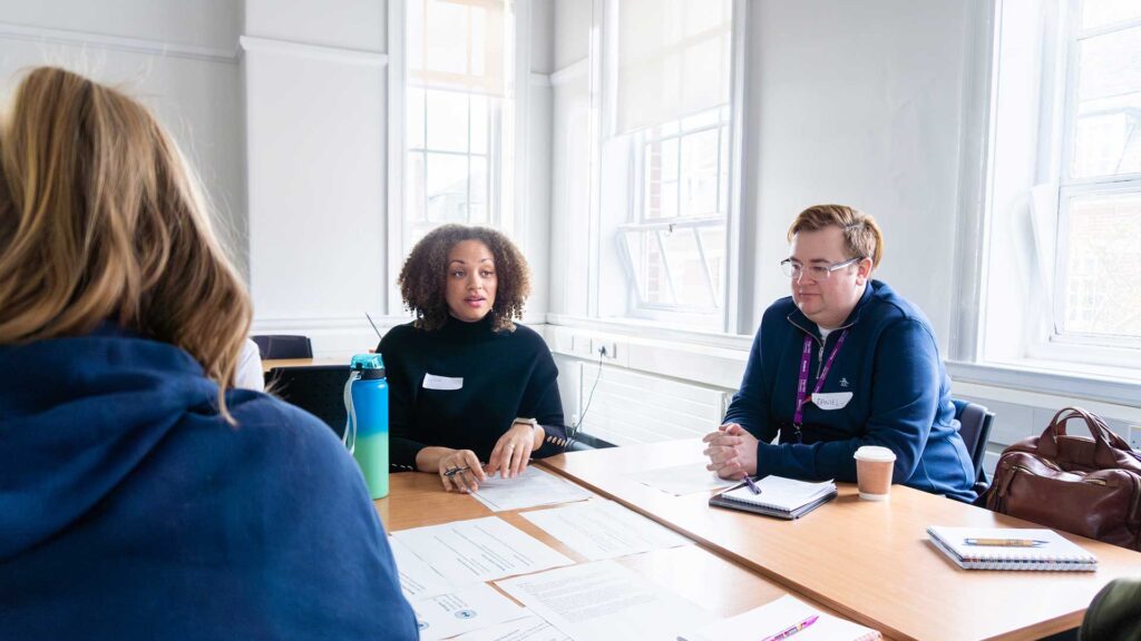 Thrive students sit in discussion around a classroom table