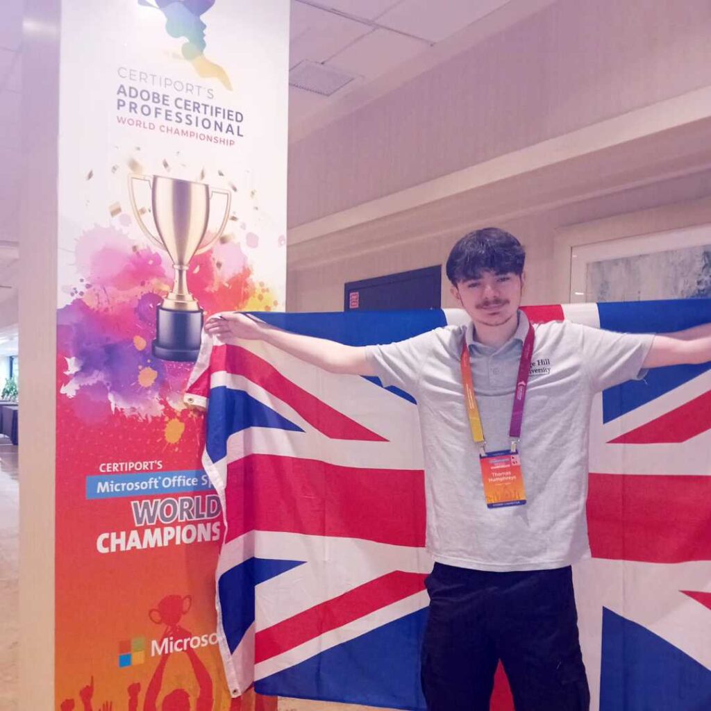 Thomas with UK flag next to MOS World Champions sign - image provided by Thomas