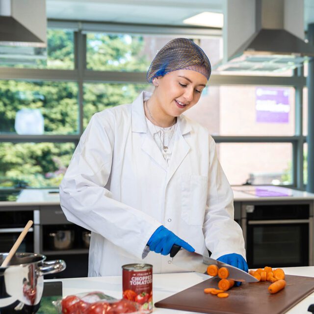 BSc (Hons) Nutrition & Health student Freya Garner chops vegetables in the food lab.